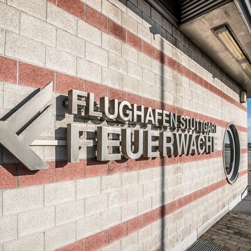 Fassade der Feuerwache am Stuttgart Airport Fassadenansicht der Feuerwache am Flughafen Stuttgart mit moderner Beschriftung und Blick aufs Rollfeld