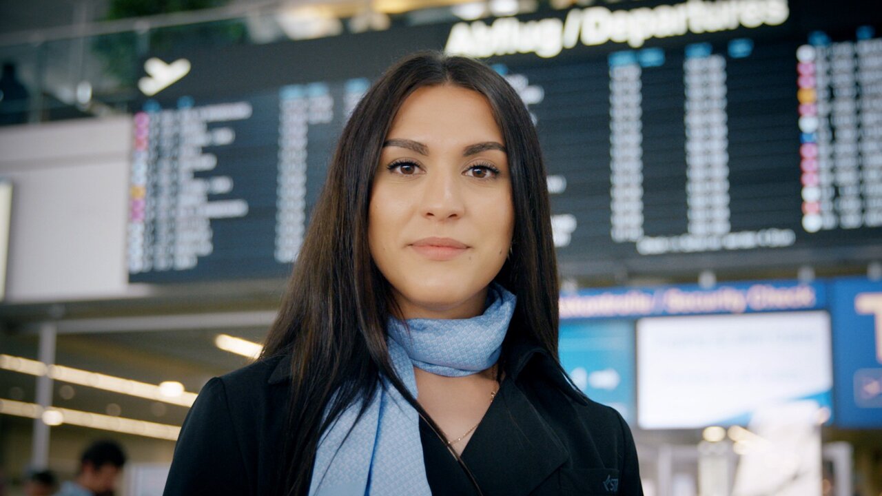 Abflug-Anzeigetafel im Flughafen Stuttgart Person steht vor einer Anzeigetafel für Abflüge im Flughafen Stuttgart.