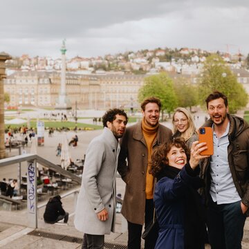 Selfie-Moment am Schlossplatz Stuttgart Eine Gruppe junger Menschen macht ein fröhliches Selfie auf der Treppe vor dem Schlossplatz in Stuttgart.